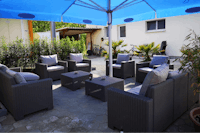 Campingplatz Oberfeld - Terrasse mit Sitzgelegenheiten unter einem Sonnenschirm
