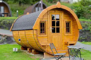 Campingplatz Odersbach - Schlaffass-Mietunterkunft mit Stromanschluss und kleiner Terrasse mit Tisch und zwei Stühlen