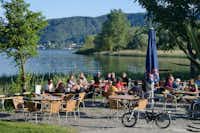 Campingplatz Schachenhorn - Aussenbereich des Restaurants mit Sitzgelegenheiten und essenden Campern
