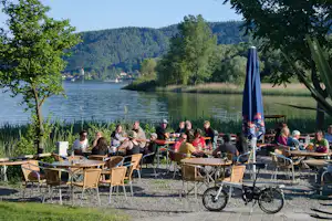 Campingplatz Schachenhorn - Aussenbereich des Restaurants mit Sitzgelegenheiten und essenden Campern