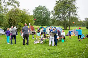 Campingplatz Stausee Hohenfelden - spielende und grillende Camper auf der Zeltwiese