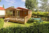 Campingred El Astral  -  Mobilheim vom Campingplatz mit Veranda und Esstisch auf grüner Wiese