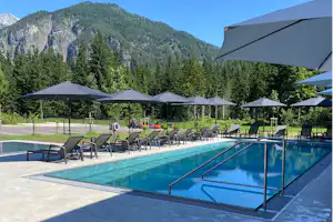 Campingresort Hinterstoder - Pool im Freien mit Liegestühlen und Sonnenschirmen