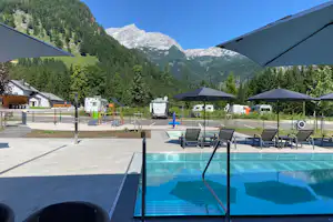 Campingresort Hinterstoder - Pool im Freien mit Liegestühlen und Sonnenschirmen