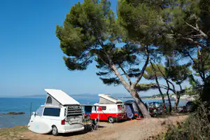 Campéole Le Dramont - Camper auf Stellplätzen direkt am Meer unter Bäumen