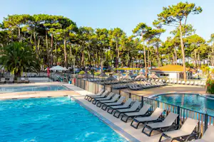 Camping Campéole Plage Sud Camping Club Plage Sud - Pool im Freien mit Liegestühlen und Sonnenschirmen