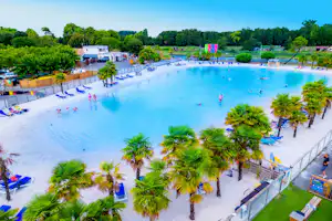 Großes Camping-Schwimmbecken mit Palmen, Liegen und Stegen, im Hintergrund Gebäude und Bäume.