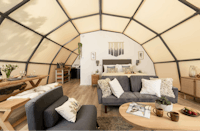 Capfun Camping Clawford Lakes - Innenansicht einer Mietunterkunft mit Doppelbett, Wohn- und Essbereich
