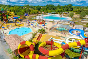 Wasserrutschen und Kinderbecken auf einem Campingplatz, mit großem Pool, Liegen und Spielbereich im Grünen.