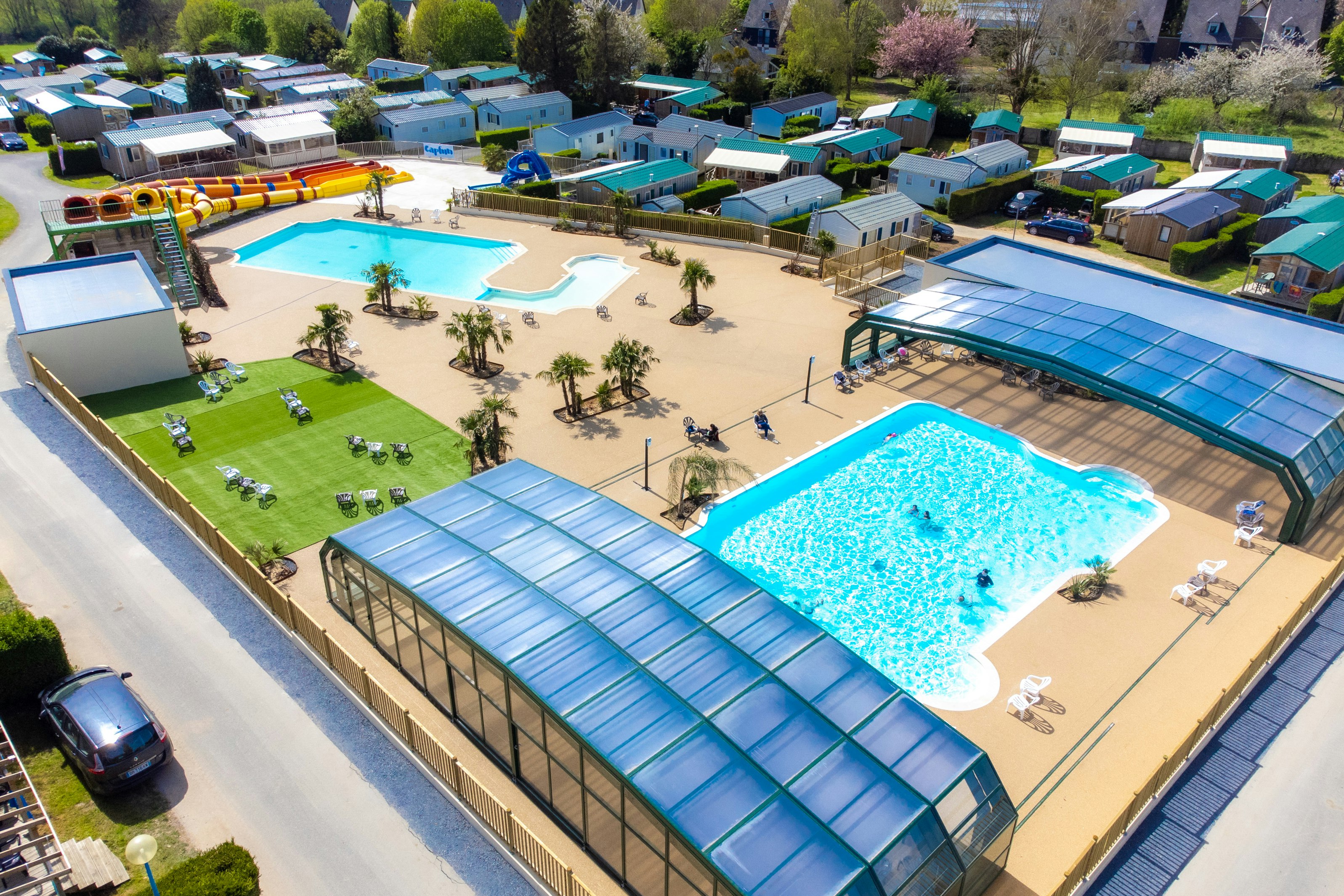 Camping Les Haras de Deauville  Capfun camping Les Haras de Deauville - Blick auf die Pools auf dem Campingplatz mit Mobilheimen im Hintergrund