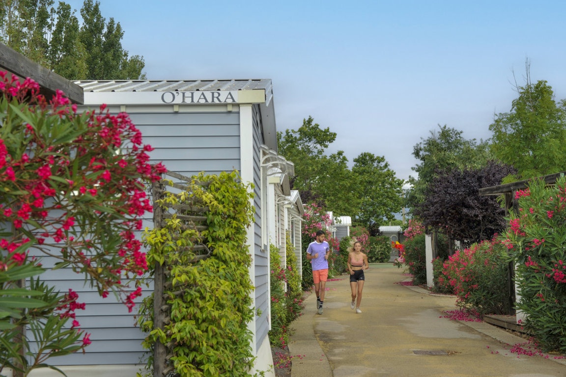Capfun camping L'Hermitage - Gäste joggen auf dem Gehweg zwischen den Mobilheimen