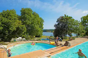 Castel Camping Le Château de Poinsouze - Camper im Pool vom Campingplatz mit Blick auf den See