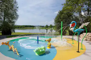 Castel Camping Le Château de Poinsouze - Kinderbecken vom Campingplatz mit Spielplatz und Blick auf den See