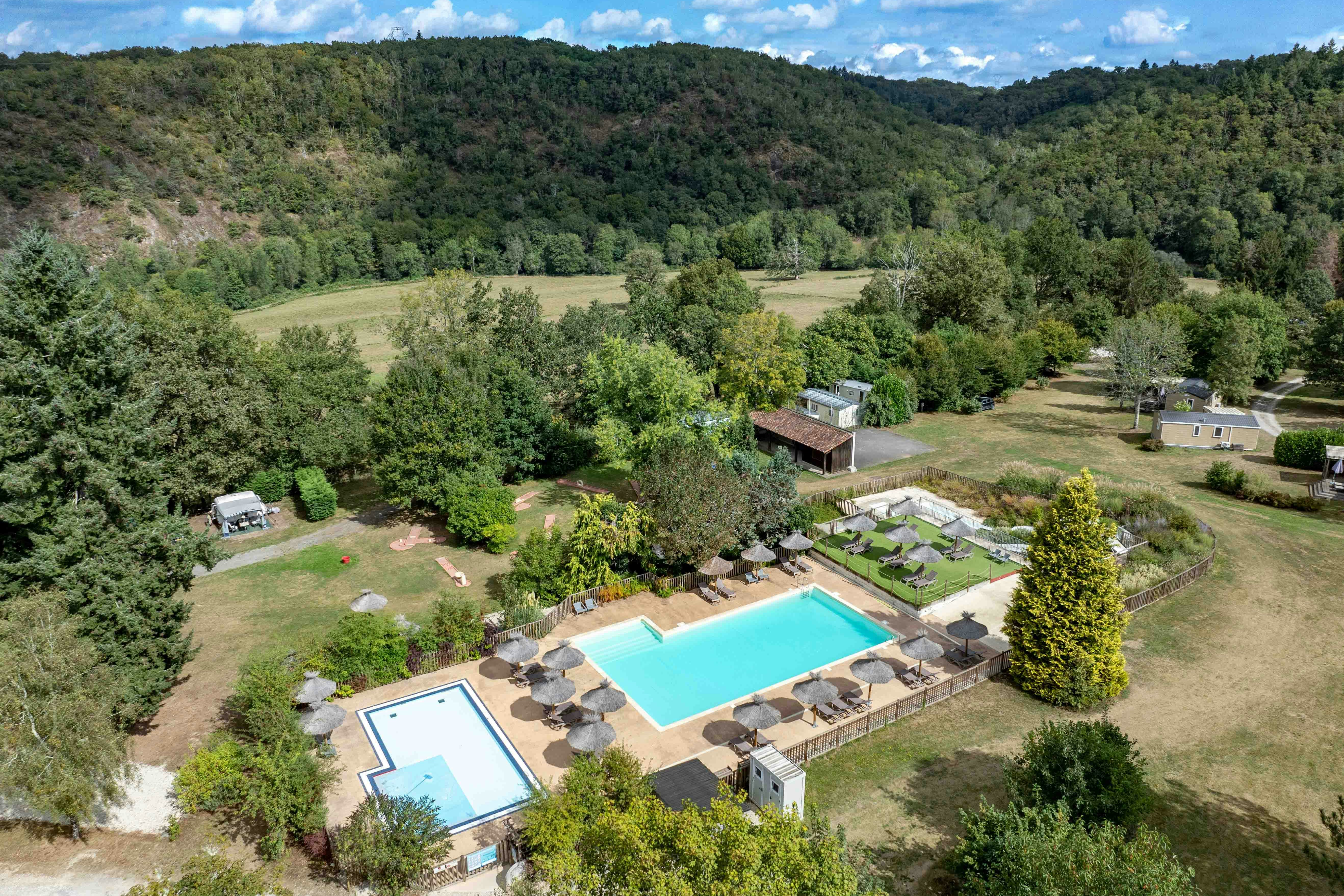 Camping Koawa Les Gorges du Chambon  Camping Les Gorges du Chambon - Ciela Village  - Pool im Freien mit Liegestühlen und Sonnenschirmen aus der Vogelperspektive