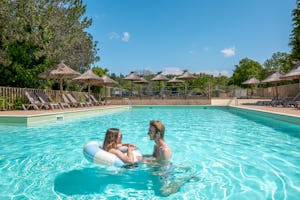 Camping Les Gorges du Chambon - Pool im Freien mit Liegestühlen und Sonnenschirmen