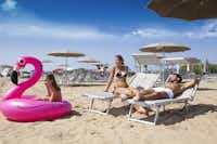 Club Camping Jesolo International - Familie entspannt sich auf Liegestühlen am Strand