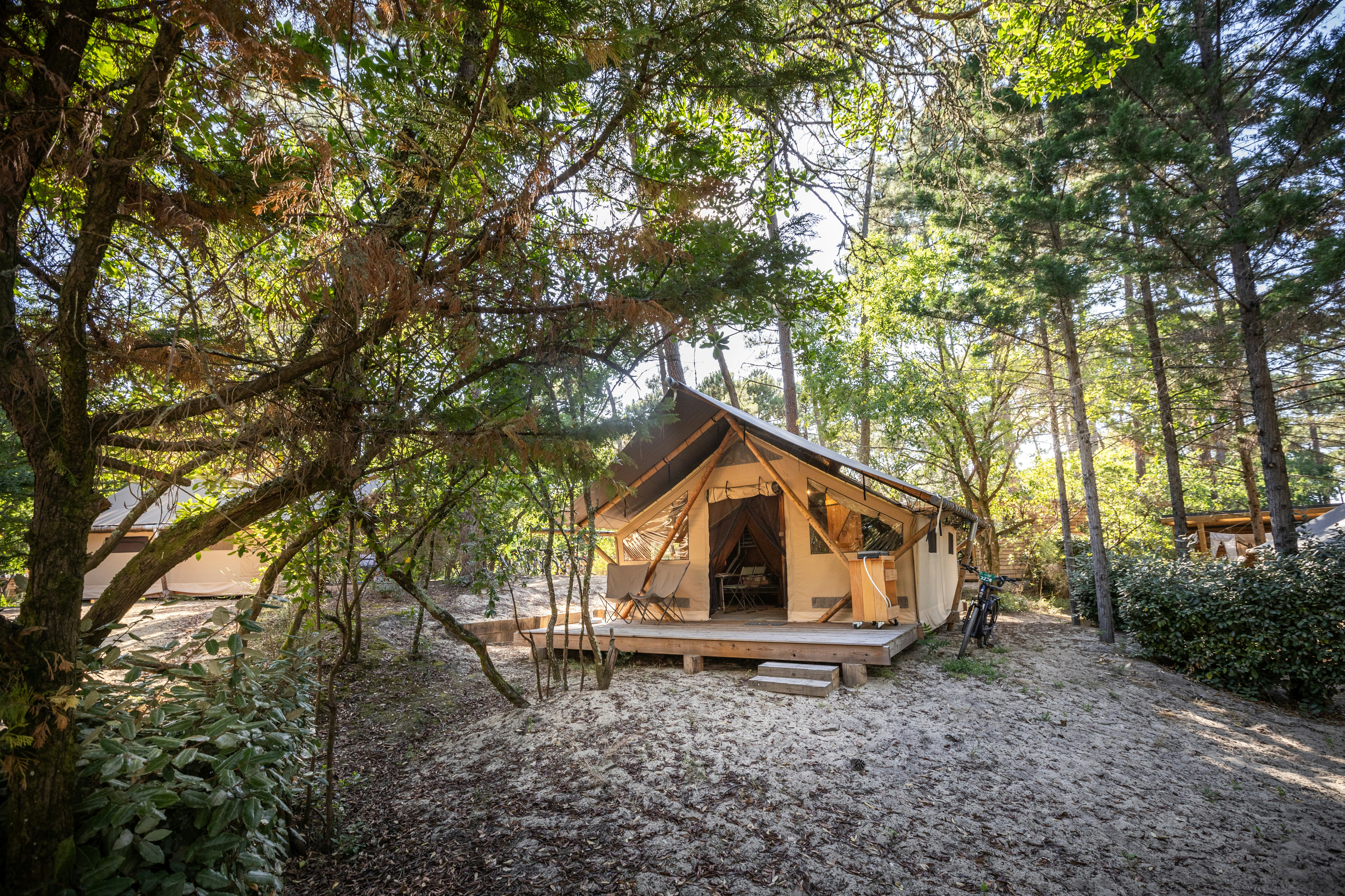 Huttopia Arcachon - Blick auf ein Glamping-Zelt mit Terrasse auf dem Campingplatz