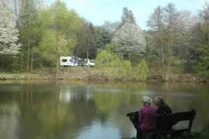 Country-Camping Schinderhannes - Gäste am See vor dem Campingplatz mit Blick auf den Campingbereich