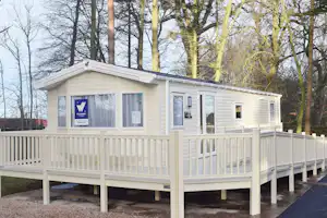 Craigtoun Meadows Holiday Park - Mobilheim vom Campingplatz mit Veranda zwischen Bäumen