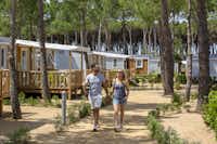 Cypsela Resort - Spazierweg im Wald zwischen Wohnwagen und Mobilheimen auf dem Campingplatz