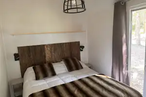 Damona Lodges - Doppelbett in einer Ferienwohnung