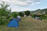 Rock Land Camp  -  Zeltplatz vom Campingplatz auf grüner Wiese mit Bergblick