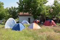 Rock Land Camp - Zeltwiese mit Zelten, im Hintergrund das Gemeinschaftsgebäude vom Campingplatz