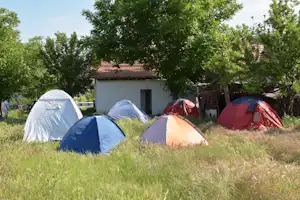 Rock Land Camp - Zeltwiese mit Zelten, im Hintergrund das Gemeinschaftsgebäude vom Campingplatz