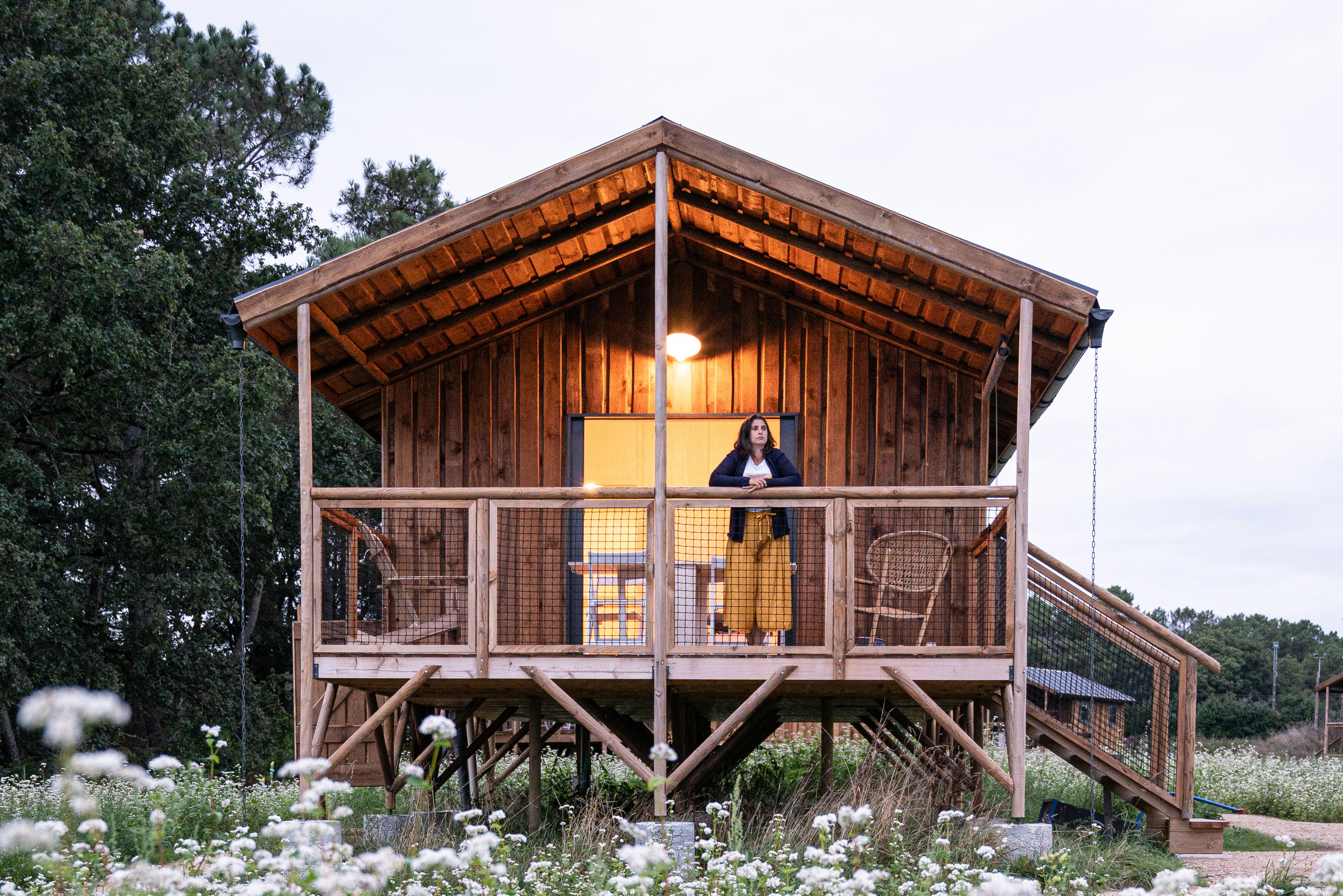 Dihan - Tree houses - Camperin genießt die Aussicht von der Terrasse eines Mobilheims