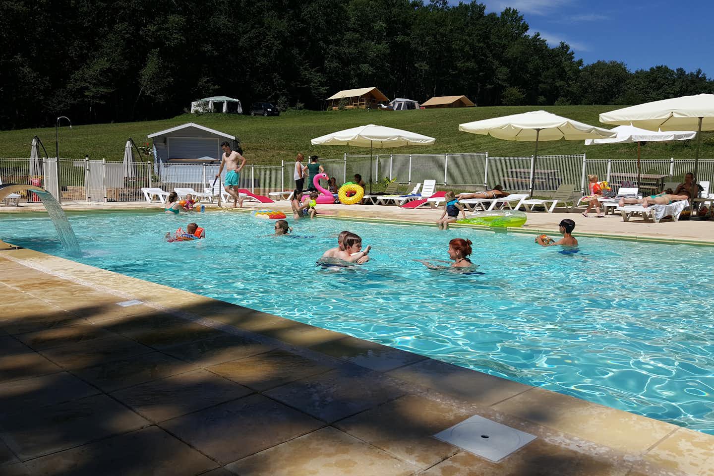 Domaine de Corneuil - Campingplatzanlage mit Pool und Liegestühlen in der Sonne