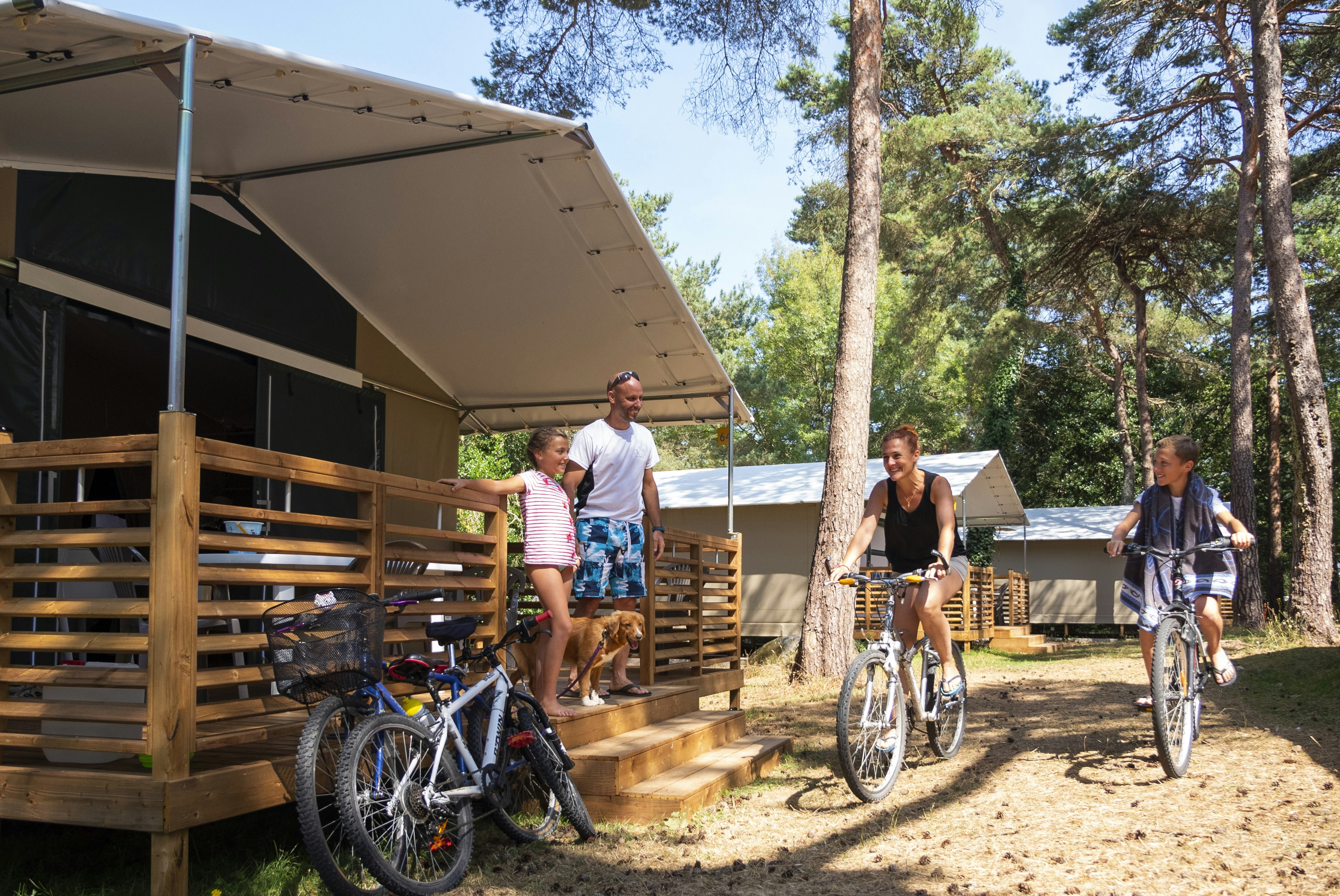 Domaine de la Pinède - Familie mit Fahrrädern vor einem Glamping-Zelt