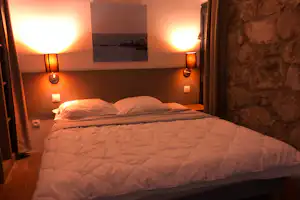 Domaine des Vans - Doppelbett im Schlafzimmer eines Mobilheims
