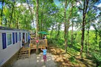 Domaine La Paille Basse  -  Camper auf der Veranda vom Mobilheim auf dem Campingplatz im Grünen