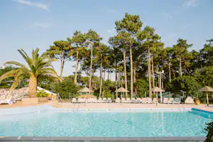 Domaine Naturiste Arnaoutchot - Pool mit Liegestühlen und Sonnenschirmen auf dem Campingplatz