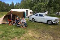 Doro Camping Lappland -  Camper sitzen vor dem Wohnmobil im Schatten der Markise