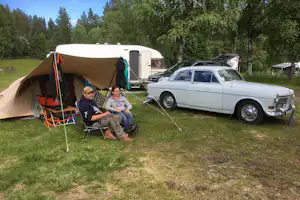 Doro Camping Lappland - Camper sitzen vor dem Wohnmobil im Schatten der Markise