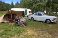 Doro Camping Lappland -  Camper sitzen vor dem Wohnmobil im Schatten der Markise