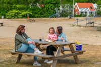 Droompark De Zanding - Gäste sitzen an einem Picknicktisch auf dem Campingplatz