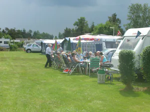Egense Strand Camping - Camper sitzen vor dem Wohnmobil in der Sonne--