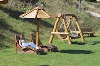 Eifel-Camp Freilinger See  -  Sonnenschirme und Liegestühle auf grüner Wiese vom Campingplatz