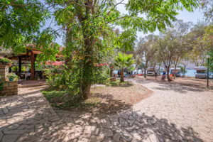 Elena's Beach Camping - Fußweg auf dem Campingplatz mit Begrünung, überdachten Sitzflächen