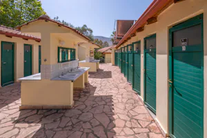 Elena's Beach Camping - Sanitärbereich mit Waschbecken im Freien und Wc- und Duschkabinen