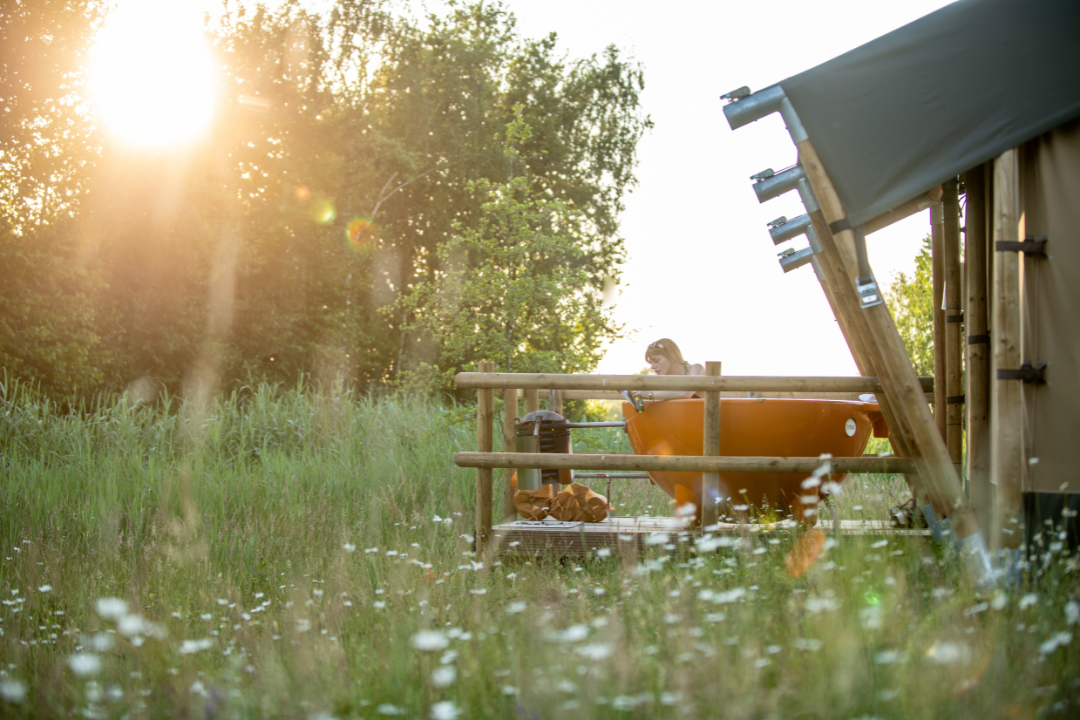 Erfgoed Bossem - Camperin entspannt auf der Terrasse eines Glamping-Zeltes