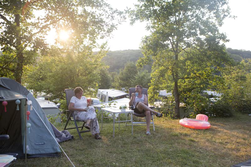 Europacamping Nommerlayen - Camper sitzen vor ihrem Zelt auf dem Stellplatz