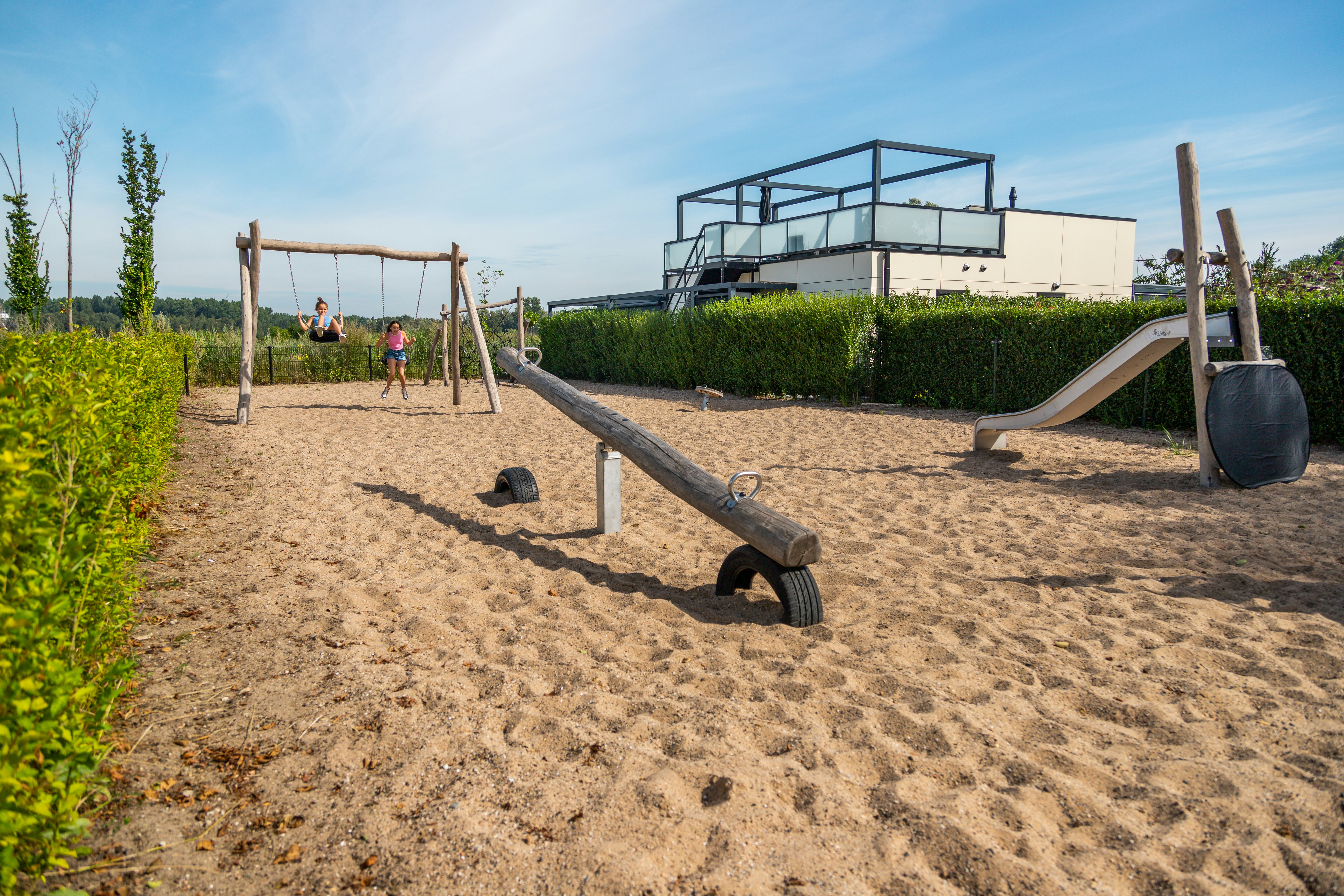 EuroParcs Bad Hulckesteijn - Spielplatz mit Schaukeln, Rutsche und Wippe auf dem Campingplatz