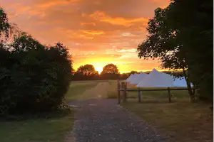 Fallow Fields Lathe Barn - Blick auf die Glamping-Wiese bei Sonnenuntergang