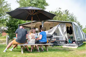 Familie Camping Nymindegab - Familie sitzt an einem Tisch auf ihrem Standplatz