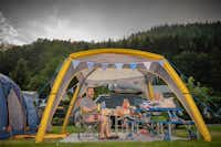 Family-Resort Kleinenzhof - Gäste des Campingplatzes die am Tisch unter einem Zelt sitzen