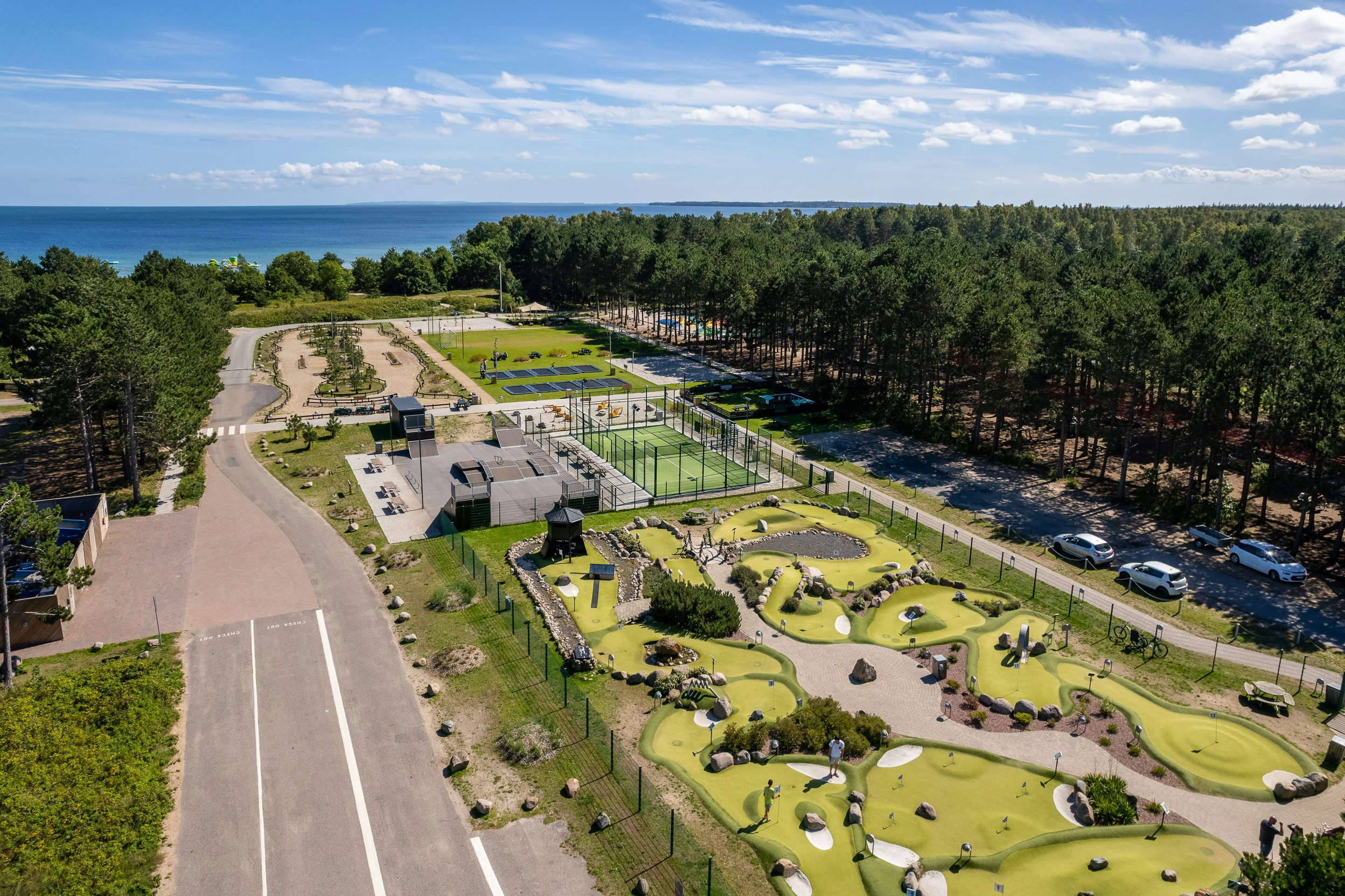 Feddet Strand Resort  Feddet Strand Camping & Feriepark - Luftaufnahme der Freizeitanlage unter anderem mit Minigolfplatz, Padeltennisplatz und Trampolinen
