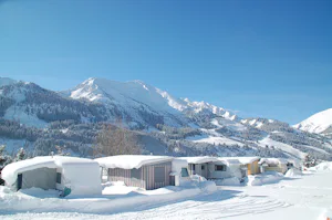 Ferienanlage Alpenwelt - Wohnmobilstellplätze im Schnee mit Blick auf die Berge